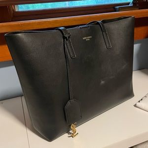 Black leather over the shoulder bag with dust cover and tag detail